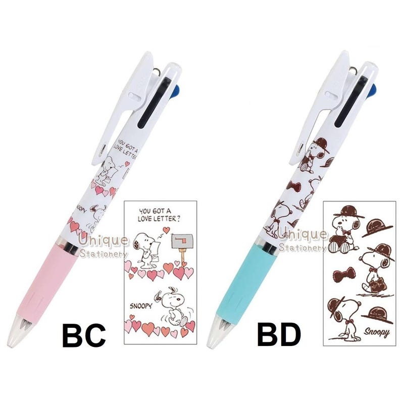 Puede incluir: Dos bol&iacute;grafos multicolores con dise&ntilde;os de Snoopy. Un bol&iacute;grafo tiene un cuerpo rosa y el otro azul claro. Ambos bol&iacute;grafos tienen la parte superior blanca y el texto "YOU GOT A LOVE LETTER?" impreso. Cada bol&iacute;grafo tiene una tarjeta a juego con ilustraciones de Snoopy.