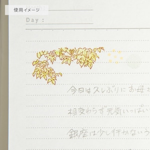 May include: A white notepad with a decorative yellow and green floral design. The notepad has lines for writing and includes Japanese text. The top of the notepad has the words "Day:" and "使用イメージ".