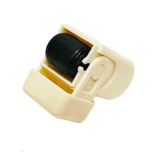 Puede incluir: Un rodillo quitapelusas de pl&aacute;stico color crema con un rodillo negro. El rodillo est&aacute; encerrado en un marco con un asa. El rodillo est&aacute; dise&ntilde;ado para eliminar pelusas, polvo y pelo de mascotas de la ropa y otras superficies.
