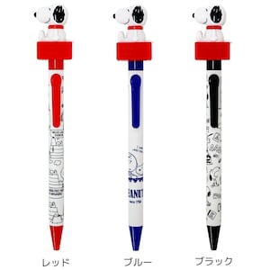 May include: Three ballpoint pens with a white barrel and black ink. Each pen has a different coloured cap: red, blue, and black. The top of each pen features a cartoon image of Snoopy, the Peanuts character. The pens are decorated with black and white illustrations of Snoopy and other Peanuts characters.