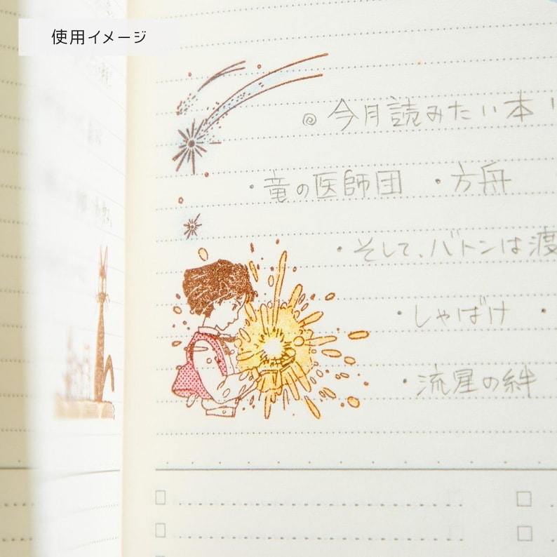 May include: A notebook page with illustrations and Japanese text. The page features a drawing of a child holding a bright light, a shooting star, and other small drawings. The text includes Japanese characters.