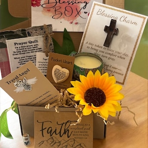 May include: A Blessing Box filled with inspirational items. Includes a prayer quilt, a pocket heart, a travel angel, a candle, a sunflower, and a card with the word "Faith" and the quote "small as a mustard seed can move mountains".