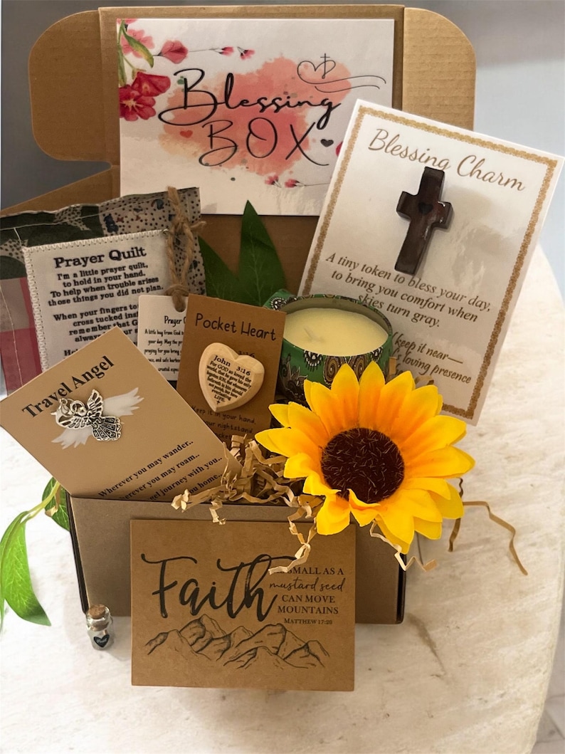 May include: A Blessing Box filled with inspirational items. Includes a wooden cross charm, a sunflower, a candle, and cards with uplifting messages. The box is decorated with floral accents and the words "Blessing Box" in script.