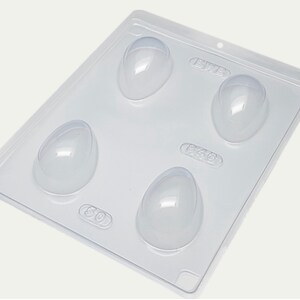 May include: A clear plastic mold with four egg-shaped cavities. The mold is designed for making chocolate eggs. The mold has numbers on each cavity: 50, 646, 646, and 878.