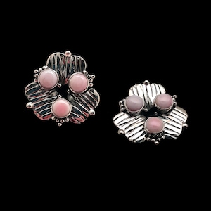May include: A pair of silver earrings with a flower design and pink stones.