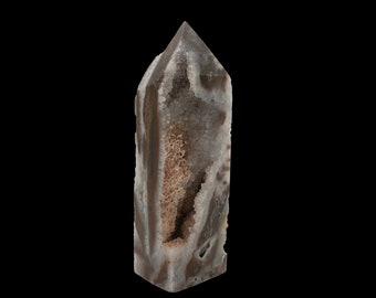 May include: A brown and white agate crystal point with a hollow centre. The crystal is polished and has a smooth surface.