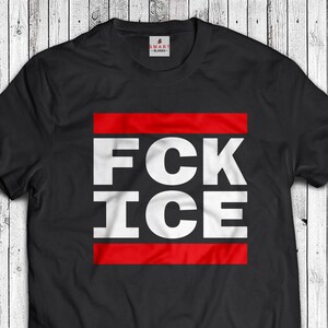 May include: Black t-shirt with the text "FCK ICE" in large white block letters, set within a red rectangle. The shirt has a crew neck and short sleeves. The brand logo "SMART BLANKS" is visible on the upper back.