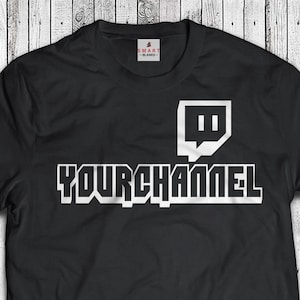 May include: Black t-shirt with a white Twitch logo and the text "YOURCHANNEL" printed on the front.