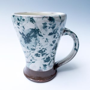 濃い緑の花のモチーフが入った手作りの陶器のマグカップ、陶器のティーカップまたはコーヒーカップ