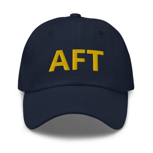 May include: A navy blue baseball cap with a yellow embroidered "AFT" on the front.