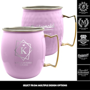 May include: Two pink metallic mugs with gold handles. The mugs are engraved with the word "bridesmaid" and a monogram. The mugs are displayed on a white background.