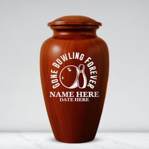 May include: A wooden urn with a dark brown finish. The urn has a lid and features a white graphic of a bowling ball and pin, with the text "GONE BOWLING FOREVER." Below the graphic is space for a name and date.