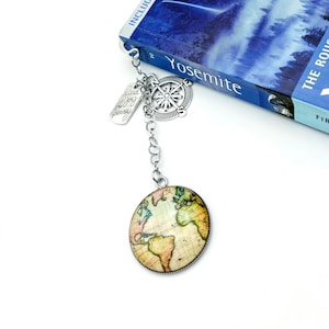May include: A silver bookmark with a compass, a tag that says "Find your joy, every journey", and a round globe charm with a vintage world map.