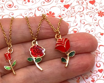 May include: Three gold necklaces with red rose pendants. Each rose is enamelled in red with green leaves.