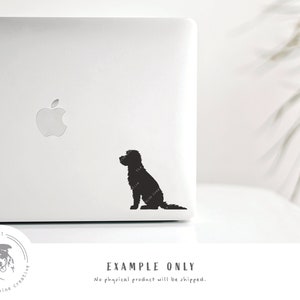 May include: A black silhouette of a dog sitting on a white laptop. The dog is facing to the left and has a long tail. The laptop has an apple logo on the lid.
