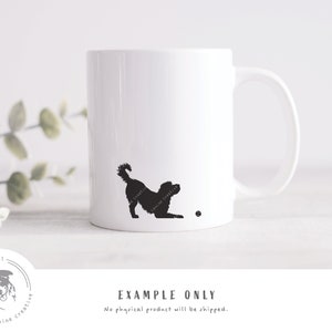 May include: White ceramic mug with a black silhouette of a dog playing fetch. The dog is facing right and has its tail wagging. The mug has a black ball on the bottom right corner.