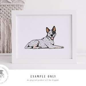 May include: A digital illustration of a blue heeler dog lying down with its tongue sticking out. The dog is white with blue and brown markings. The illustration is in a white frame.