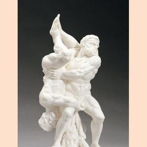 May include: A white sculpture depicting two muscular figures in a wrestling pose. One figure is lifting the other, who is upside down. The sculpture is mounted on a dark, rectangular base. The number "22-0991-1012" is at the bottom.