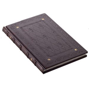 Può includere: Un diario rettangolare marrone scuro con una copertina testurizzata caratterizzata da un motivo a rombi in rilievo, bordi con volute intricate e piccoli accenti color oro. Il dorso presenta nervature con dettagli dorati e pagine bianche.