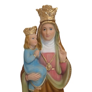 May include: A religious statue depicting a woman wearing a gold crown and holding a child, also crowned. The woman wears a pink and brown robe with a gold necklace. The child is dressed in blue. The statue has a serene expression.
