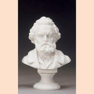 Può includere: Scultura di busto bianco di un uomo con barba e capelli ricci, che indossa una giacca e un papillon. La scultura è montata su un piedistallo. Il numero "22-1018-1010" è stampato in basso.