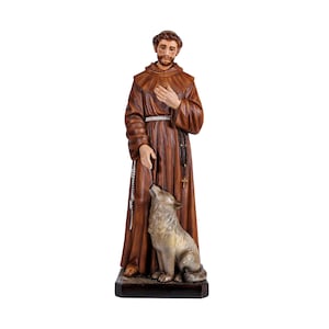 Op de afbeelding: Een gedetailleerd beeld van Sint Franciscus van Assisi in een bruine jurk, met een wolf aan zijn voeten. Het beeld heeft een rozenkrans en een serene uitdrukking. De wolf is grijs en lijkt naar Sint Franciscus te kijken.