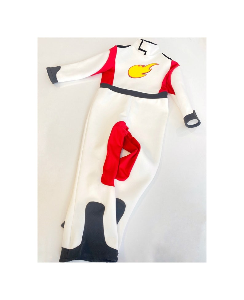 May include: White jumpsuit with red and black accents. The jumpsuit has a flame design on the chest.