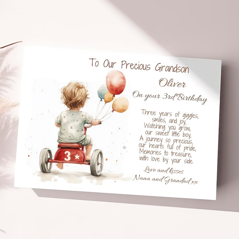 May include: A watercolor illustration of a young boy riding a red tricycle with a star and the number 3 on it. He is holding a bunch of colorful balloons. The text reads "To Our Precious Grandson Oliver On your 3rd Birthday Three years of giggles, smiles, and joy. Watching you grow, our sweet little boy, A journey so precious, our hearts full of pride, Memories to treasure, with love by your side. Love and kisses Nana and Grandad xx"