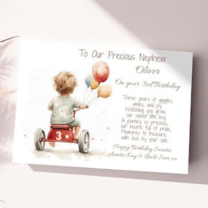 May include: A watercolor illustration of a child riding a red tricycle with a star and the number 3 on it. The child is holding balloons in their hand. The text reads "To Our Precious Nephew Oliver On your 3rd Birthday Three years of giggles, smiles, and joy. Watching you grow, our sweet little boy, A journey so precious, our hearts full of pride, Memories to treasure, with love by your side. Happy Birthday Sweetie Auntie Kay & Uncle Sam xx"