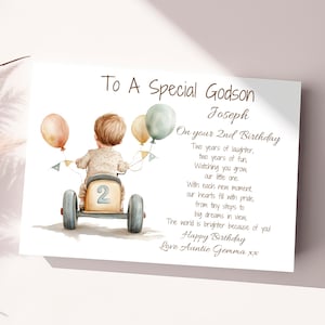 May include: A birthday card for a godson, featuring a watercolor illustration of a boy riding a toy car with balloons. The card reads "To A Special Godson Joseph On your 2nd Birthday Two years of laughter, two years of fun, Watching you grow, our little one. With each new moment, our hearts fill with pride, from tiny steps to big dreams in view, The world is brighter because of you! Happy Birthday Love Auntie Gemma xx"