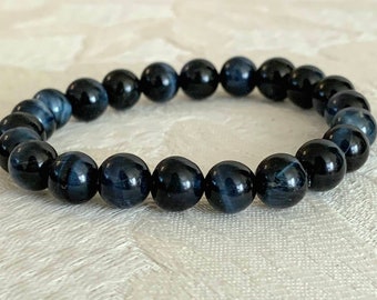May include: A blue tiger's eye beaded bracelet. The beads are round and smooth, and the bracelet is made with elastic.