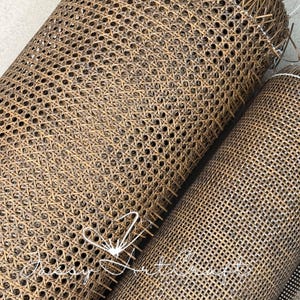 Pode incluir: Dois rolos de tela de palha trançada em castanho escuro com um padrão de malha octogonal distinto. O material apresenta um acabamento texturizado natural com fios entrelaçados visíveis. Uma marca de água branca Jassy Art Craft é visível.