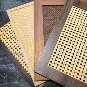 May include: A collection of rectangular wooden frames with woven cane inserts. The frames vary in color, including dark brown, light brown, and natural wood tones. The cane inserts have a light tan color and a patterned design.