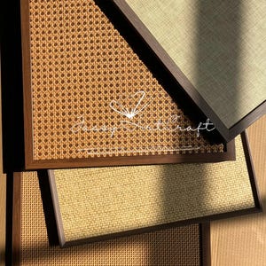 May include: A collection of framed wall art with woven and textured surfaces. The frames are dark brown, and the woven panels feature a light brown, natural color. The text "Jassy Nathcraft" is visible on one of the panels.