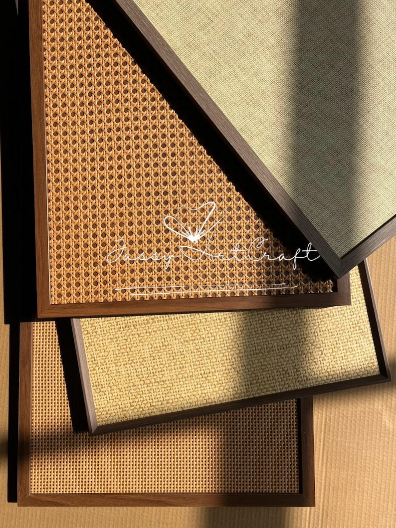 May include: A collection of framed wall art with woven and textured surfaces. The frames are dark brown, and the woven panels feature a light brown, natural color. The text "Jassy Nathcraft" is visible on one of the panels.