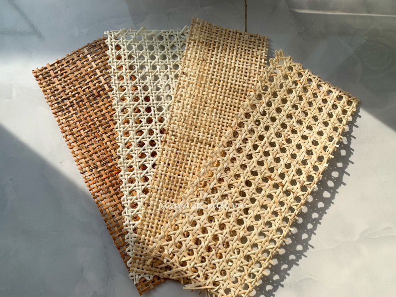 May include: Five rectangular pieces of woven cane webbing in varying shades of brown and beige. The webbing has a repeating pattern of small, evenly spaced holes, and is suitable for furniture repair or craft projects.