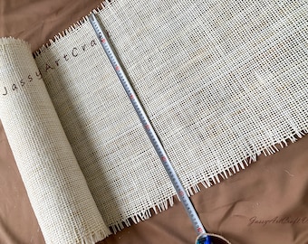 May include: A roll of white, woven mesh fabric with a frayed edge. A measuring tape is laid across the fabric, showing a measurement of 28 inches.