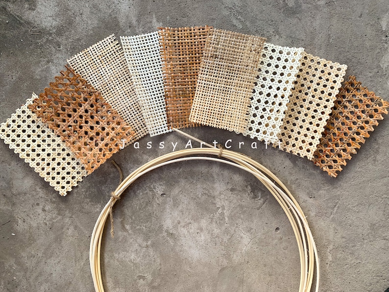 May include: Assortment of woven cane webbing samples in various shades of brown and white, arranged in a fan shape. A bundle of thin, light-colored wooden hoops is in the foreground. The text "Jassy Art Craft" is visible.