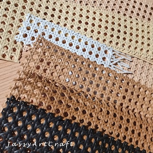 May include: Close-up of several pieces of woven cane webbing in various colors. The colors include beige, white, brown, and black. The webbing has a repeating pattern of small, evenly spaced holes.