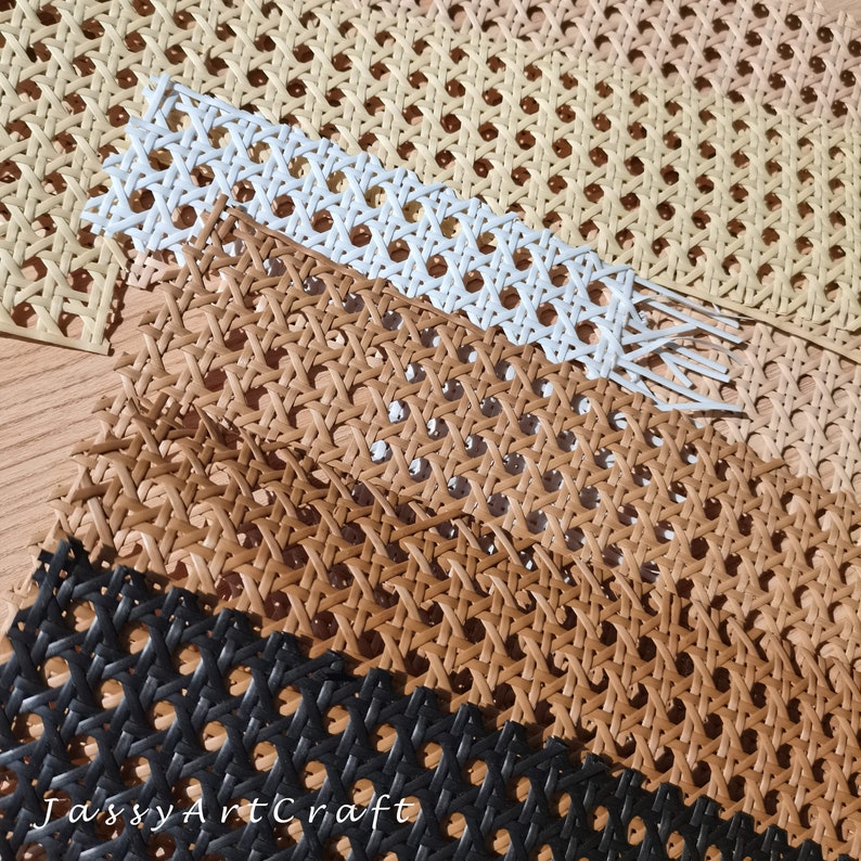 May include: Close-up of several pieces of woven cane webbing in various colors. The colors include beige, white, brown, and black. The webbing has a repeating pattern of small, evenly spaced holes.