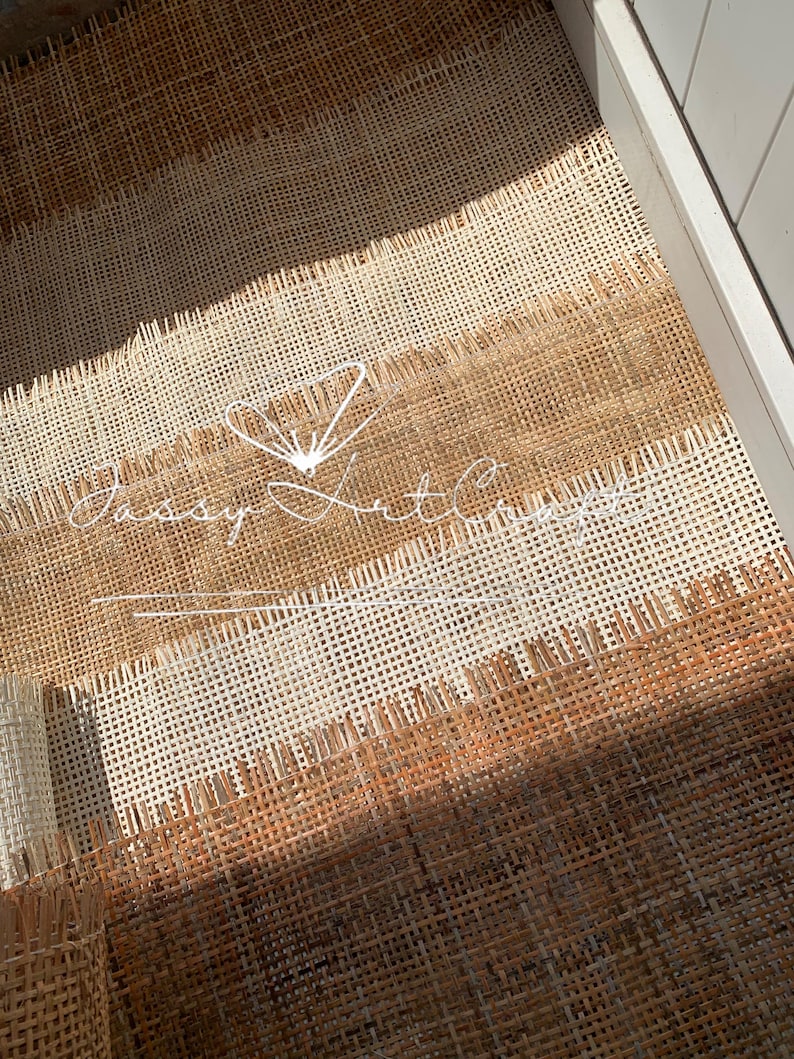 May include: Close-up of woven material in shades of brown and cream, arranged in horizontal stripes. The material has a textured, open weave. The text "Jassy Art Concepts" is visible in white script. The material appears to be inside a white drawer.