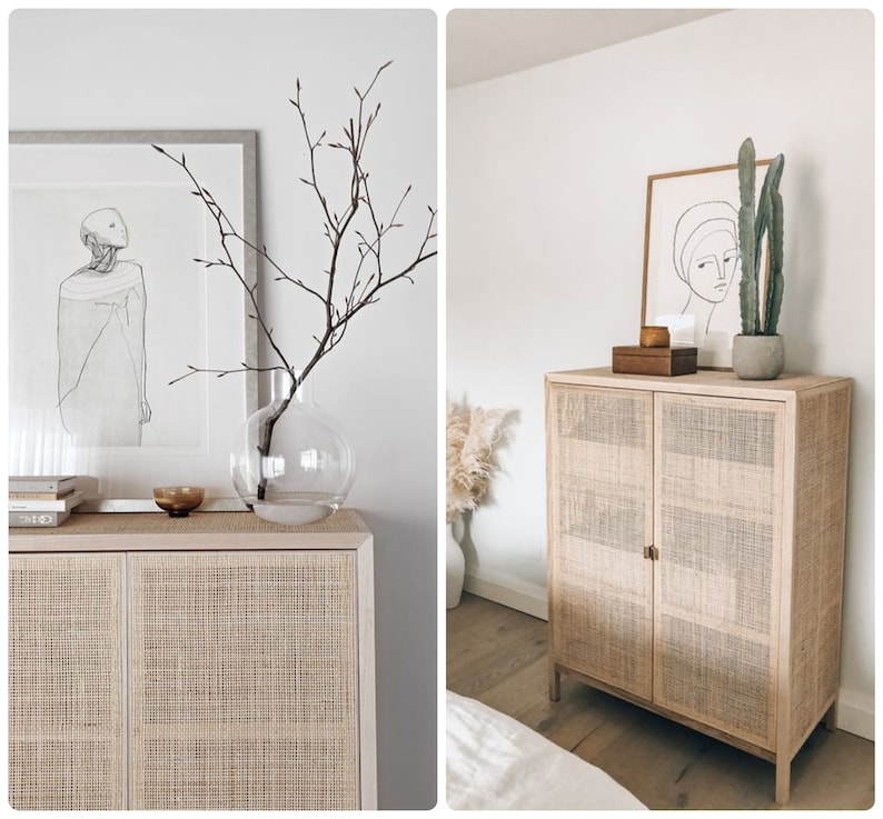 May include: A white wicker cabinet with two doors, a light wood top, and a cactus plant in a brown pot on top. The cabinet is in a room with white walls and a white rug.