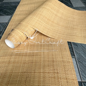 May include: A roll of natural-colored woven material, partially unrolled, revealing a textured surface. The material appears to be made of woven fibers, possibly for use as a decorative element or craft supply. The text "Sassy Art Craft" is visible.
