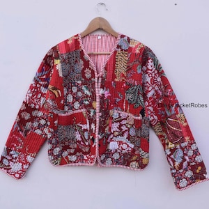 May include: Red quilted jacket with a floral print and a white and red striped lining. The jacket has a V-neck and a button closure. DressJacketRobes is printed on the right sleeve.