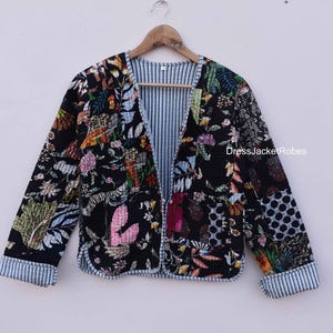 May include: A black quilted jacket with a floral print and a striped lining. The jacket has a button closure and long sleeves.
