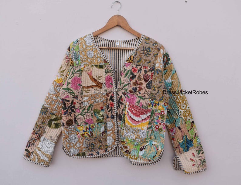May include: A beige quilted jacket with a floral print and a V-neck. The jacket has a striped lining and a black trim.