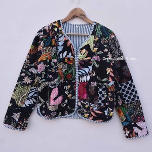 May include: A black quilted jacket with a floral print. The jacket has a V-neck and a button closure. The fabric is a patchwork of different floral patterns in shades of pink, blue, green, and yellow.