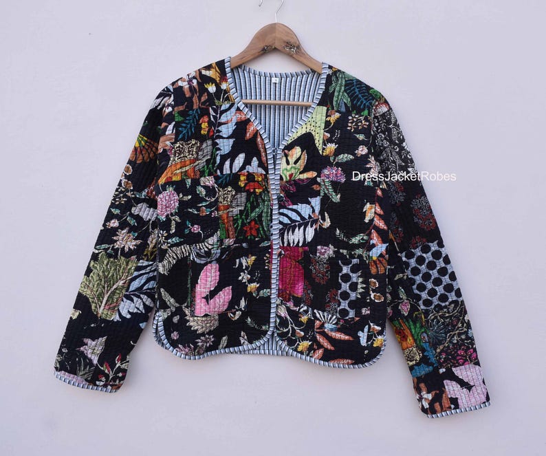 May include: A black quilted jacket with a floral print. The jacket has a V-neck and a button closure. The fabric is a patchwork of different floral patterns in shades of pink, blue, green, and yellow.