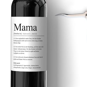 May include: A black wine bottle with a white label that reads "Mama [Stefanie]  Safe haven,  Family" and a definition of the word "Mama". The label also includes the text "LABELED with LOVE" and a website address.