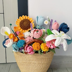 Op de afbeelding: Een gehaakt boeket bloemen in een rieten mand. Het boeket bevat zonnebloemen, lelies, tulpen en andere bloemen in verschillende kleuren.